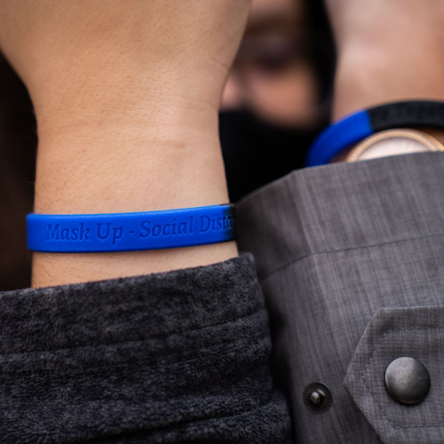 Students hand out wristbands to encourage COVID-safe behaviors